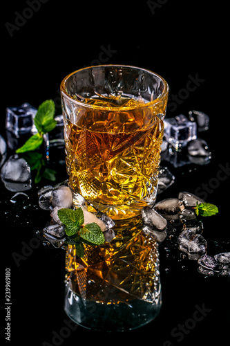 Elite drink for masculine relaxation glasse of whiskey and ice on black background, copy space. concept luxury drink