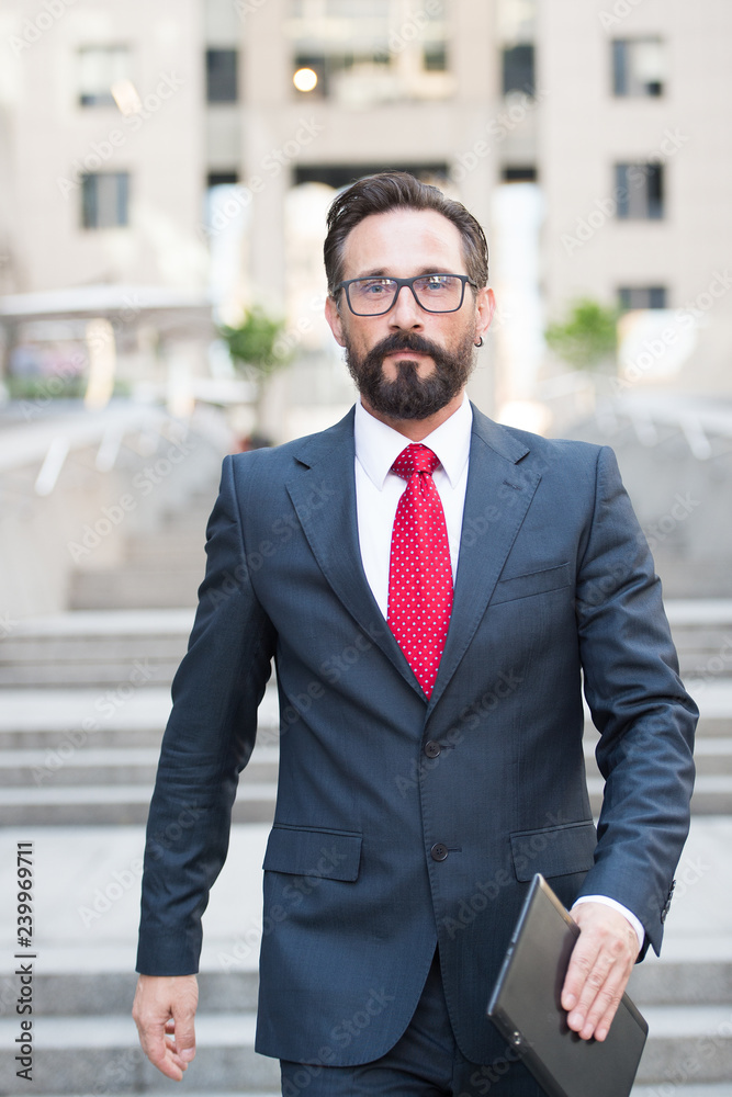 Confident handsome businessman walking down city stairs Confident handsome businessman walking down city stairs