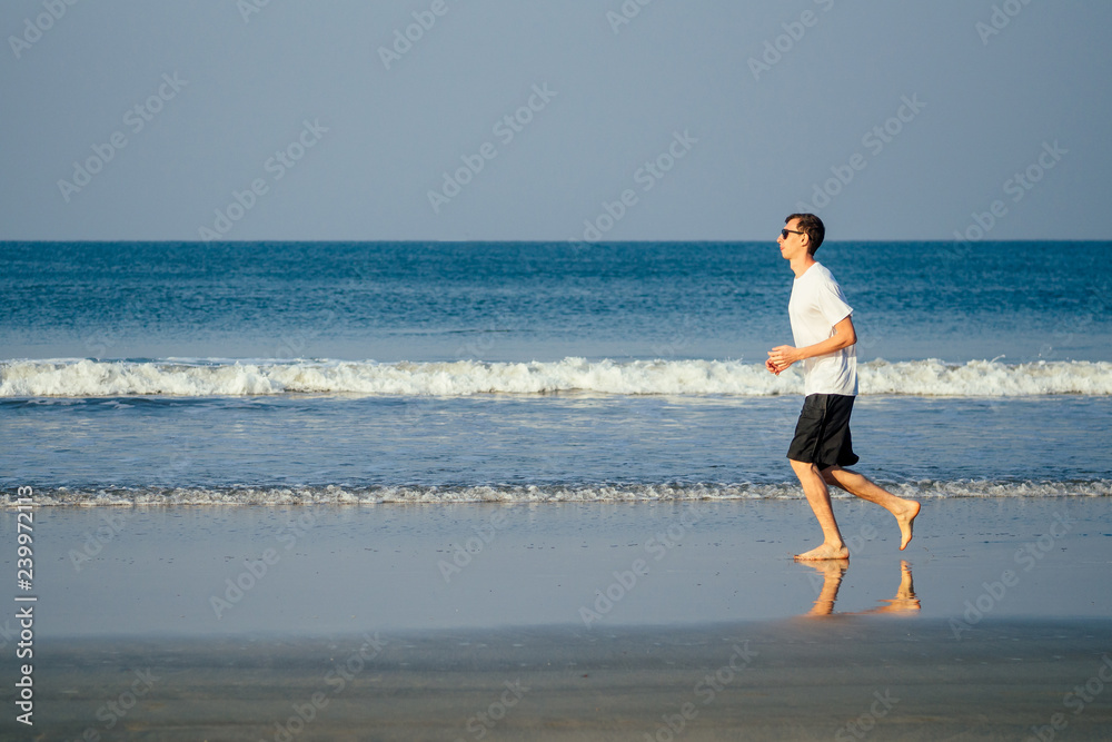 copy space caucasian man training on the beach in morning. Young fitness male on morning run outdoors copyspace sky, sea landscape.healthy way,cardio and detox copy space caucasian man training on the beach in morning. Young fitness male on morning run outdoors copyspace sky, sea landscape.healthy way,cardio and detox
