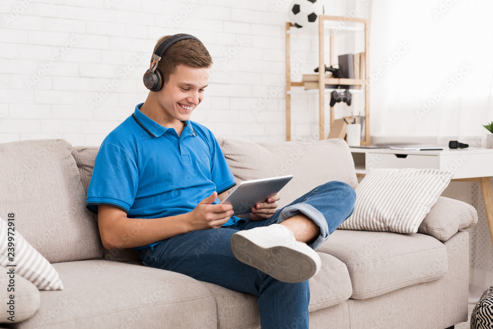 Happy teenager chatting online on digital tablet Happy teenager chatting online on digital tablet