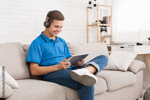 Happy teenager chatting online on digital tablet