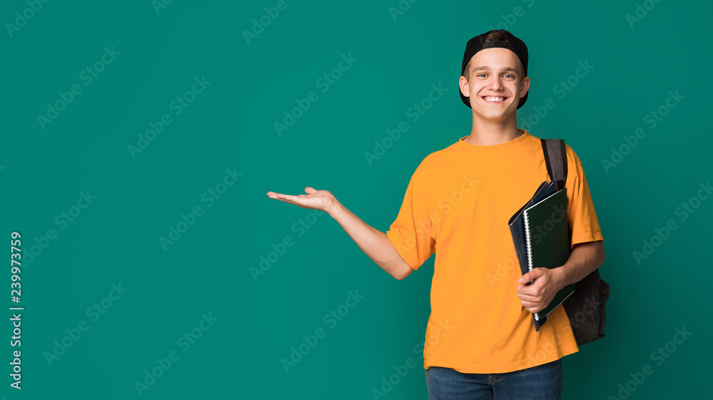 Happy student with books holding something on palm