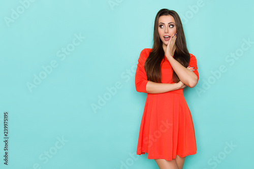 Surprised Young Woman Is Holding Hand On Chin And Looking Away