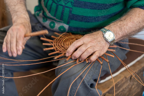  A basket weaver at work in the factory shop in Camacha on Madeira Island,  Portugal photo