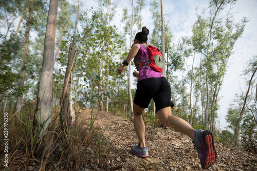 Fototapeta Naklejka Na Ścianę i Meble -  Sportswoman cross country trail running in forest