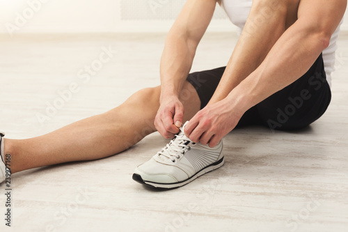 Closeup of a man tying shoelaces in gym