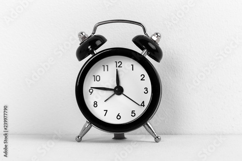 Black vintage alarm clock on a white background close up