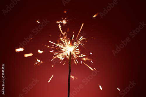  New Year's sparkler on a red background. Celebration