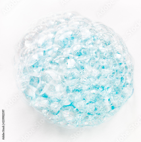 Soap bubbles on a white background from blue shower gel  top view.