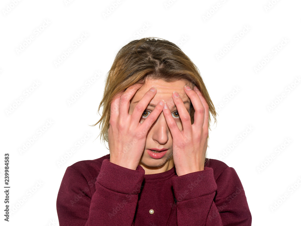 The woman in sweater covered her face with hands. She feels great fear. Girl isolated on white background. The woman in sweater covered her face with hands. She feels great fear. Girl isolated on white background.