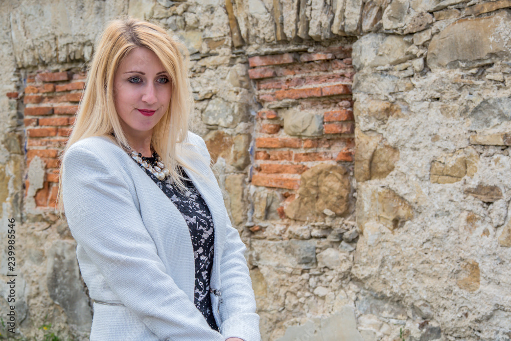 Beautiful girl dressed up for baptism ceremony posing in front of castle ruins. Beautiful girl dressed up for baptism ceremony posing in front of castle ruins.