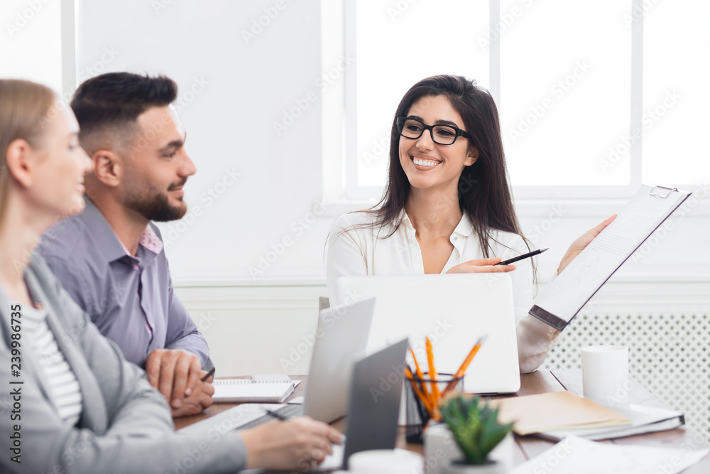 Businesswoman showing good statistics report at meeting Businesswoman showing good statistics report at meeting