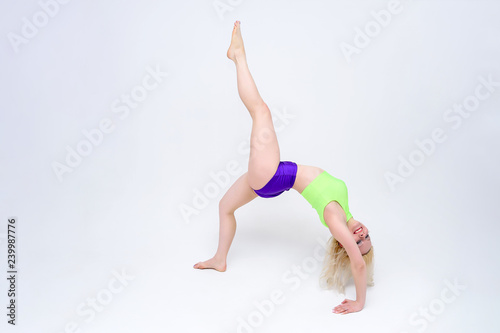 concept girl on a white background sitting on a twine in a dance suit