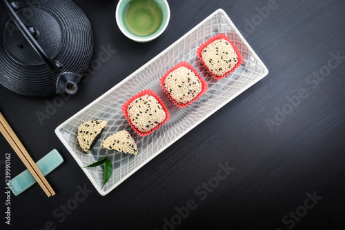 Mochi assortment on plate with chopticks and green tea photo