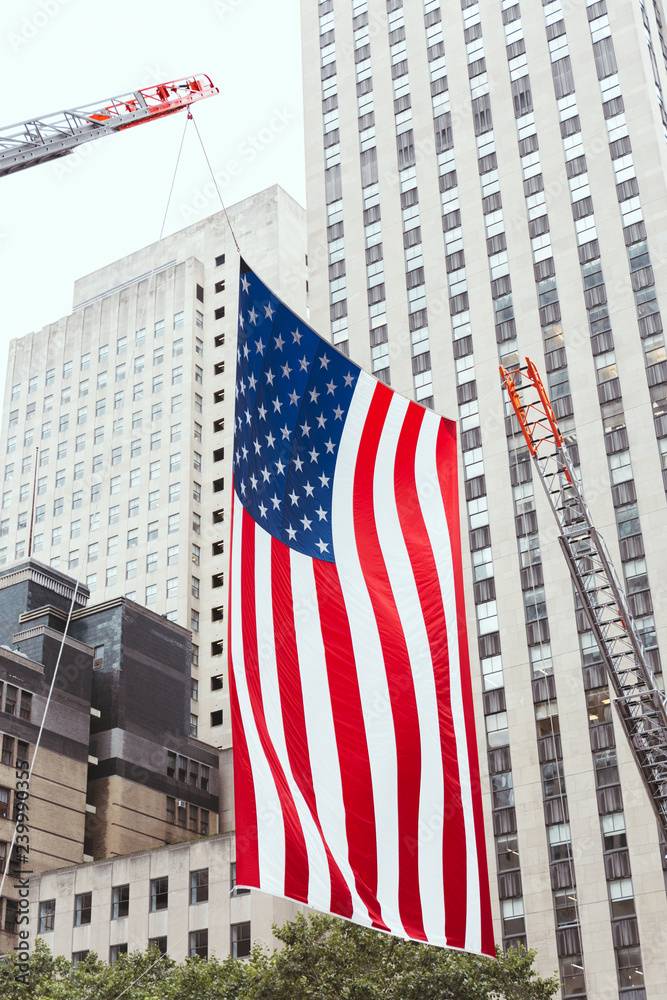 close up view of american flag and buildings in new york city, usa