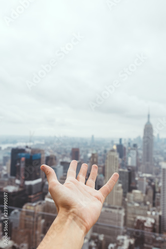 partial view of male hand and blurry new york city view on background
