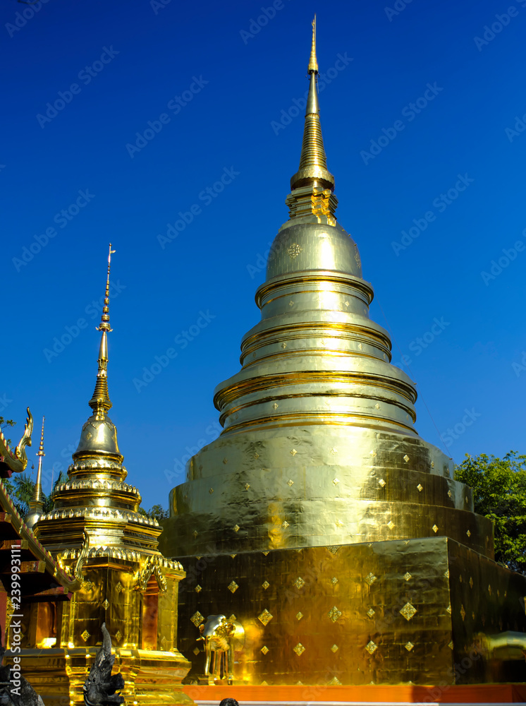 Naklejka premium Thai pagoda covered with gold cut with blue sky.