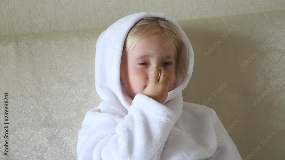 Young children in the beauty salon with cucumbers on their face. Girls in white coats and towels on their heads make nourished cucumbers on their face. Young children in the beauty salon with cucumbers on their face. Girls in white coats and towels on their heads make nourished cucumbers on their face.