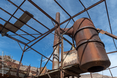 A rusty tank suspended on scaffolding in an abandoned lead mine near Bonnie Claire, Nevada, USA photo