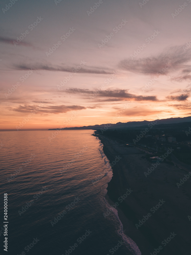Bellissimo cielo al tramonto infuocato con nuvole arancione e rosso in riva all'oceano calmo. Vista aerea