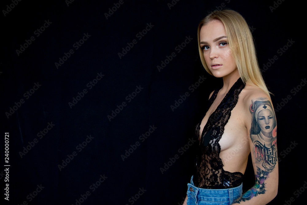 a studio shot of a young woman with tattoo a studio shot of a young woman with tattoo
