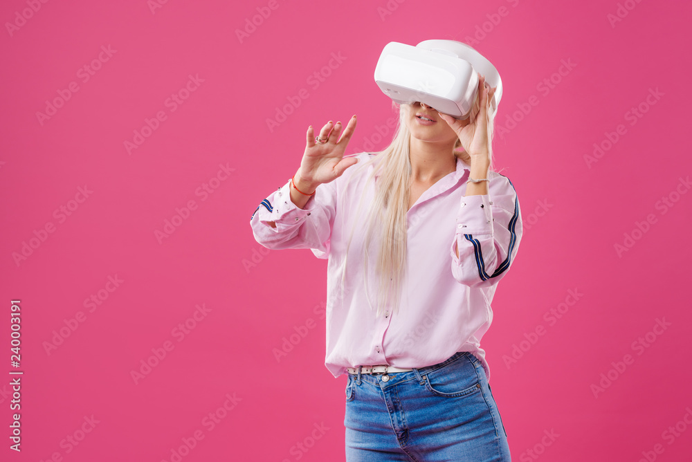 Young Blond happy woman student with virtual reality goggles. Studio shot on pink background. Virtual learning Young Blond happy woman student with virtual reality goggles. Studio shot on pink background. Virtual learning