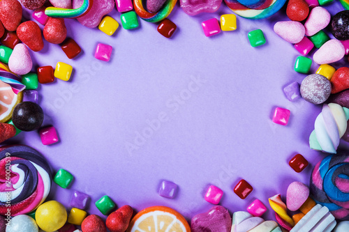 sweets are different on a black background, candy, gum, candy on a purple background