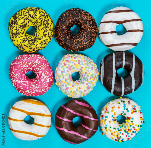 Fototapeta assorted donuts covered with eating, chocolate, nuts on blue background