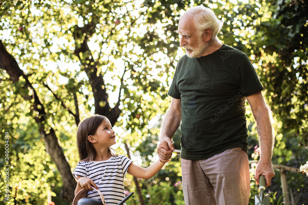 Crandfather with his granddaughter in beautiful sunny garden Crandfather with his granddaughter in beautiful sunny garden
