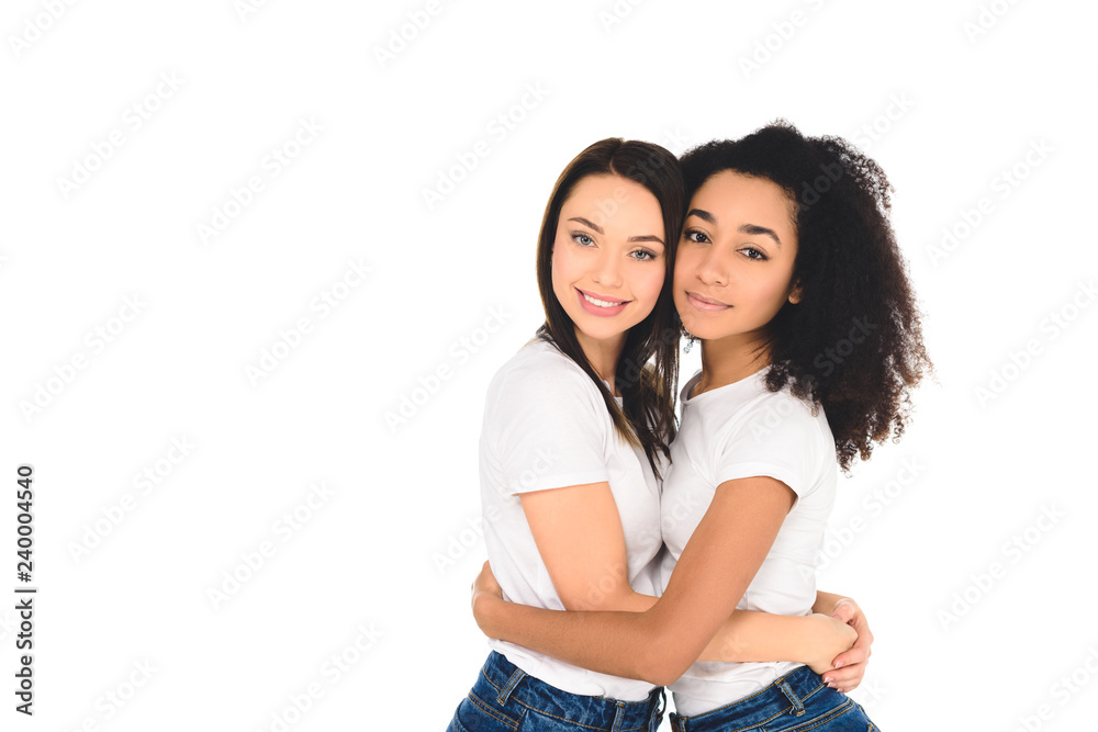 multicultural friends in white T-shirts hugging and looking at camera isolated on white multicultural friends in white T-shirts hugging and looking at camera isolated on white