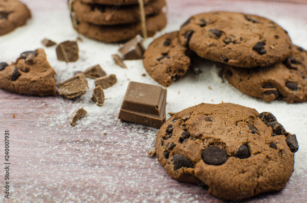 Fototapeta premium freshly baked chocolate chip cookies on rustic wooden table