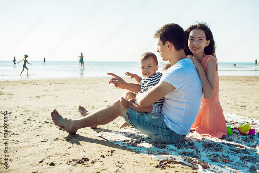 Fototapeta premium Cheerful multi ethnic family have a rest on a sea shore.