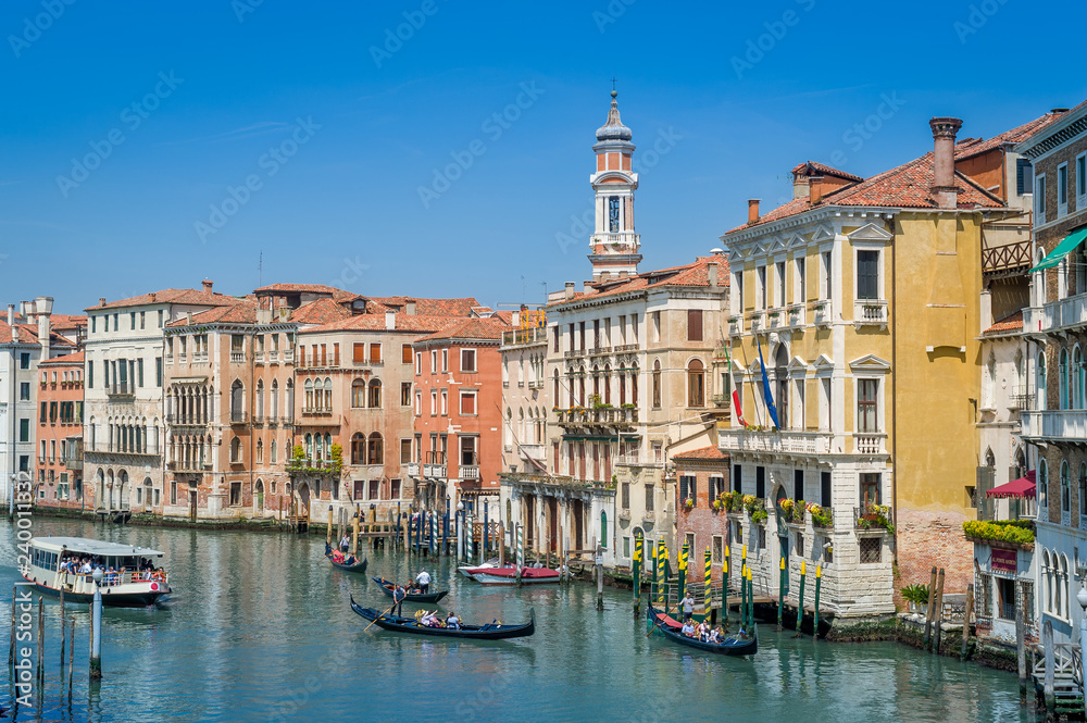 Traditional gondolas and touristic boat at the Grande Channel of Venice.