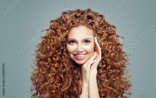 Beautiful redhead woman with long curly hair isolated on white. Haircare concept