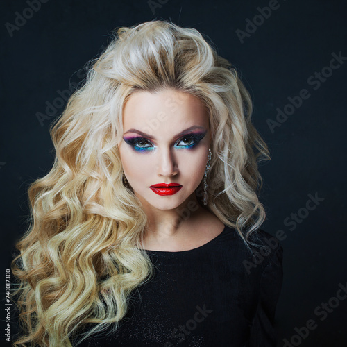 Portrait of a young luxurious blonde with long curls.