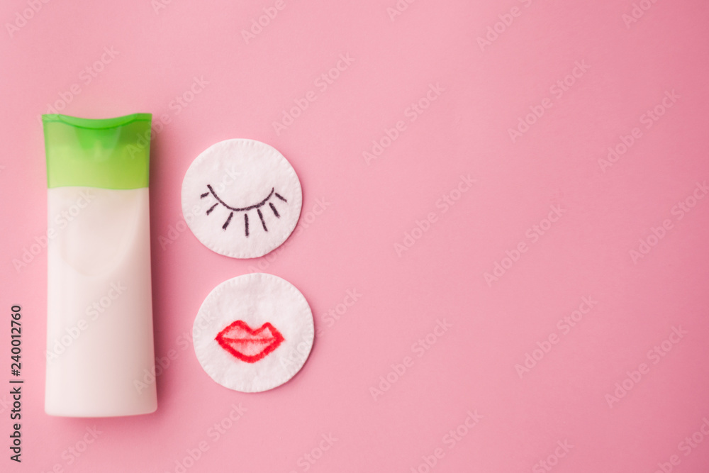 cleansing cream for the face and a cotton pad with a remuver. pink background. makeup removal. skin care. top view. selective focus. cleansing cream for the face and a cotton pad with a remuver. pink background. makeup removal. skin care. top view. selective focus.