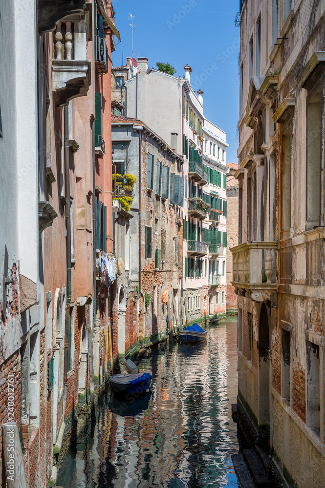 Obraz premium Mały kanał starego miasta w Wenecji z pięknymi refleksami na wodzie