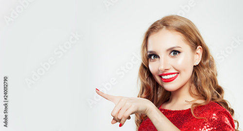 Young happy woman pointing finger on white background with copy space