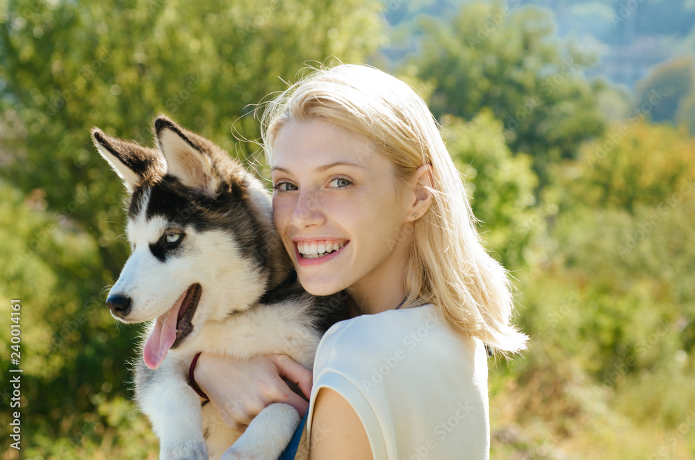 This girl loves her siberian husky. Sexy woman with dog pet on summer day.  Happy girl