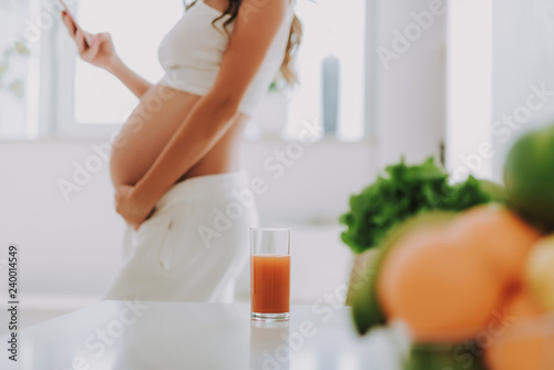 Juice on table in front of pregnant lady