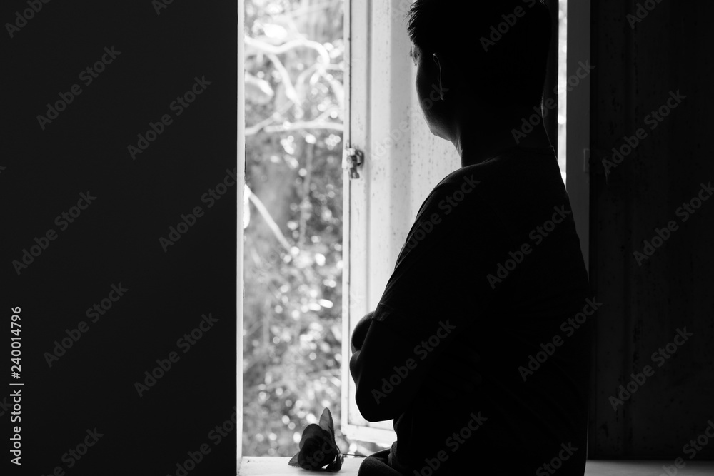 Sad man thinking and looking from windows with rose in valentines day.B&W style
