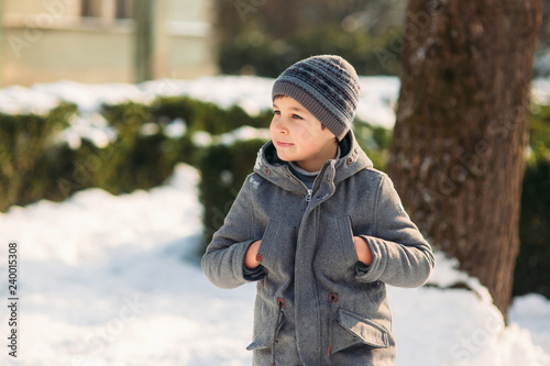 Boy walkink in the park at winter holiday. Christmas mood photo