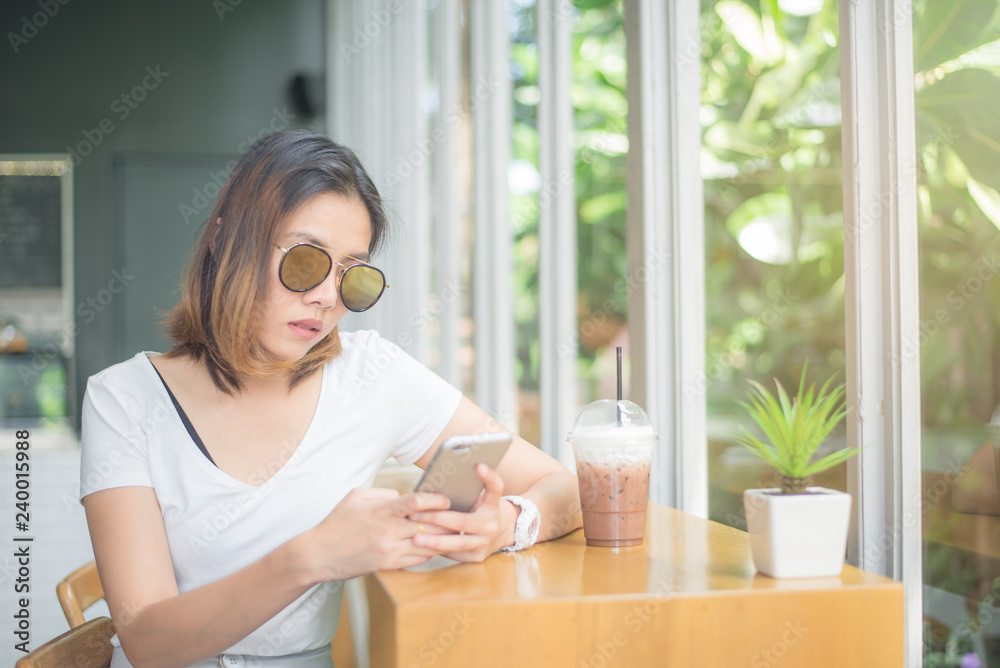 Asian young woman sitting by the window in the cafe. Asian young woman sitting by the window in the cafe.