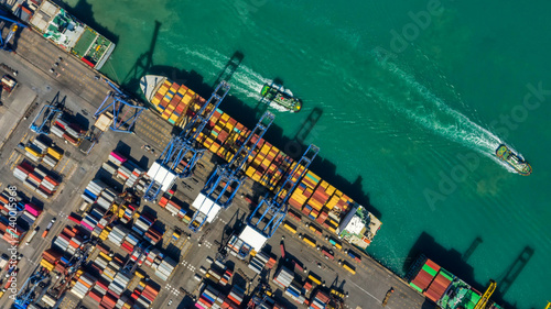Container ship in export and import business logistics and transportation. Cargo and container box shipping to harbor by crane. Water transport International. Aerial view and top view. © MAGNIFIER