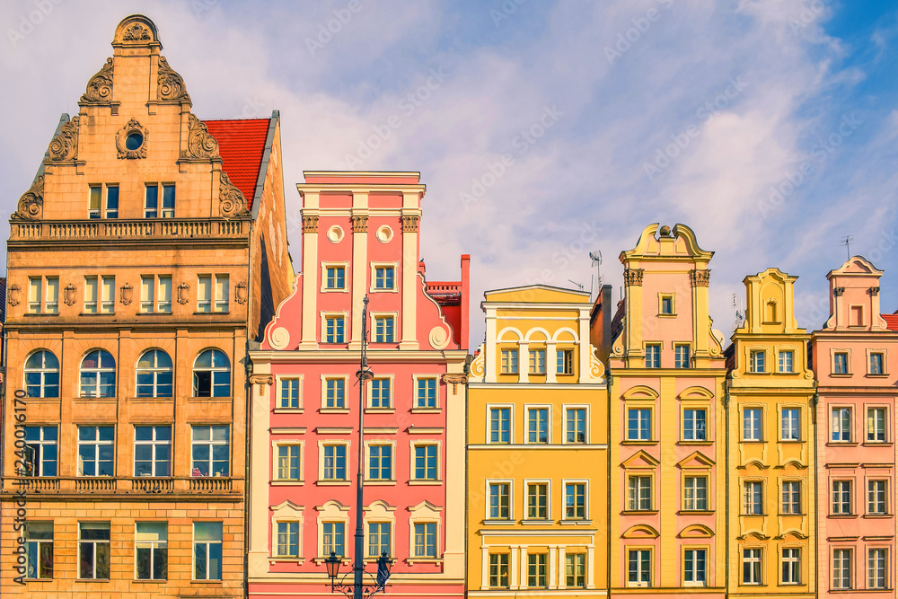 Market square tenements in Europe. Beautiful and colorful facade of historical buildings. Front view with roofs.