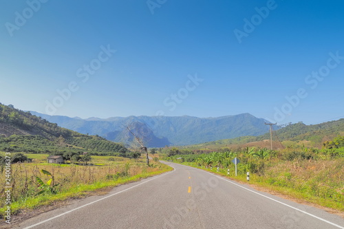 Scenic highway route 1148, view on the road around with green meadow, mountain and blue sky background, Tham Sakoen National Park, Nan, northern of Thailand.