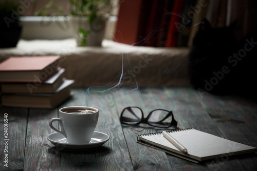 A cup of coffee in the workplace on a wooden table.