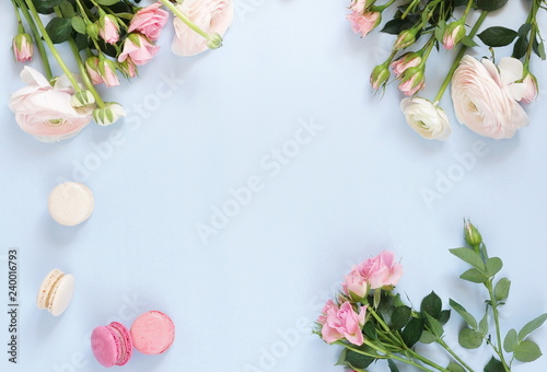 Flowers background. Pink flowers roses and ranunkulus on pale blue background. Top view. Copy space. Holiday concept
