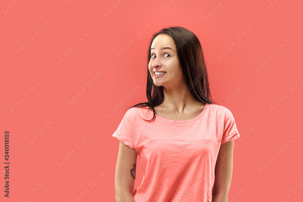 Obraz premium Wow. Beautiful female half-length front portrait isolated on coral studio backgroud. Young emotional surprised woman standing with open mouth. Human emotions, facial expression concept. Trendy colors