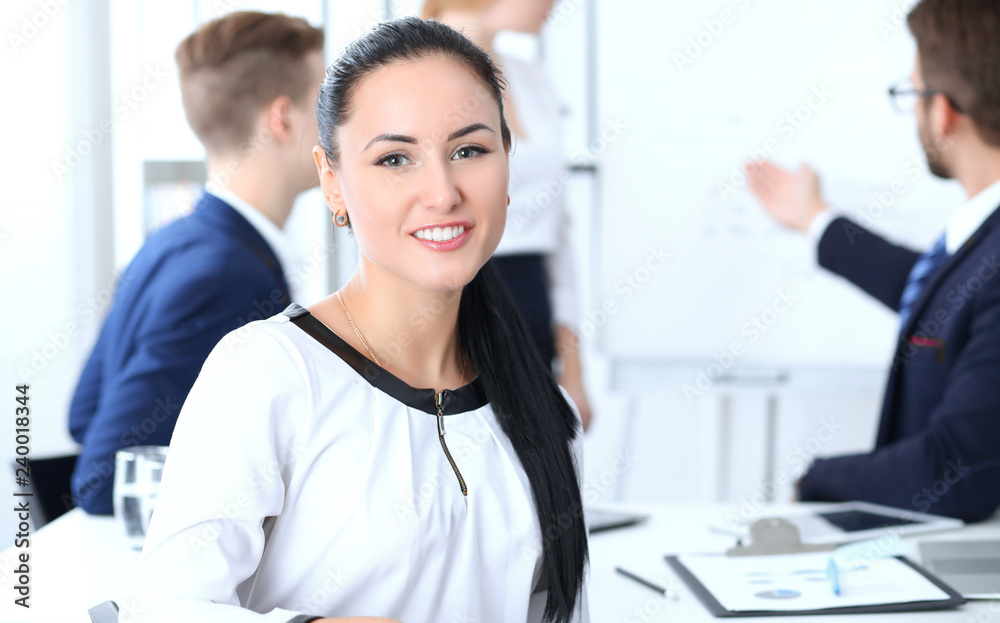 Business People group at meeting in office. Focus at beautiful cheerful smiling businesswoman. Conference, corporate training or brainstorming of team. Success and  negotiation concept